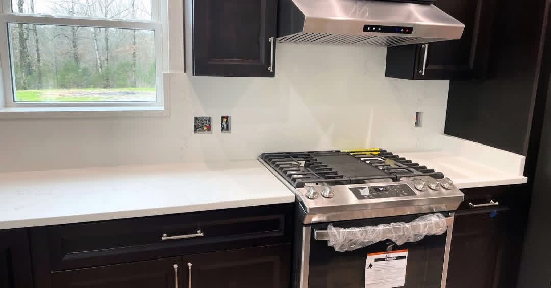 White quartz countertops beside a new gas range
