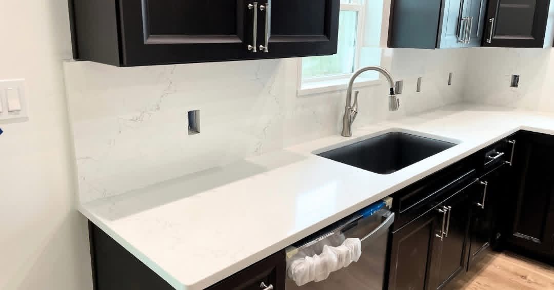 White quartz countertop and full-height backsplash with an undermount sink